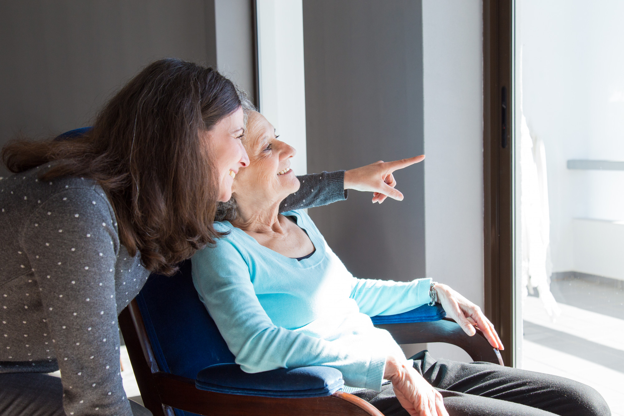 caregiver supports older adult woman at home