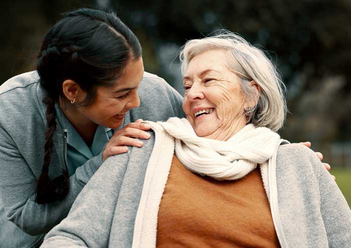 Caregiver with older woman care recipient seated outside
